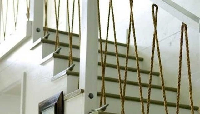 Nautical theme handrail featuring boat dock cleats anchored to the floor with ropes strung between them and a top plate, ideal for unique deck railing designs.
