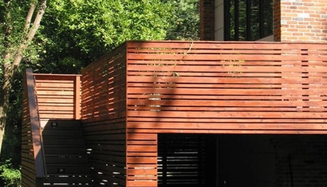 Artfully designed wooden privacy screen patio rails featuring elegant offset boards, offering a balance of openness and seclusion for deck railing designs.