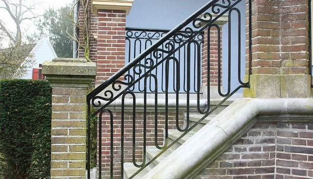 A brick front porch handrail and stairs railing featuring an up and down squiggle pattern with modified sideways figure 8s, showcasing unique deck railing designs.