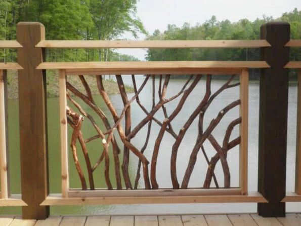 A Lissara style handrail section featuring twisted Mountain Laurel branches, with a serene lake visible in the background.