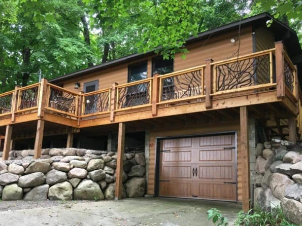 Lissara style handrails featuring dark stained Mountain Laurel branches and light-colored handrail wood on a log mountain home.