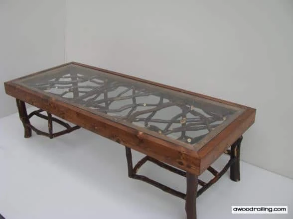 A stylish coffee table featuring laurel branches as legs and a glass tabletop, showcasing a unique design.