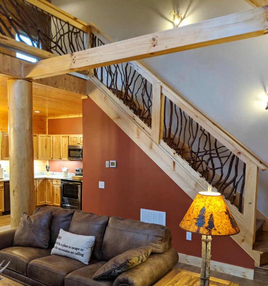 A stylish stair railing featuring a light wood handrail complemented by dark stained laurel branches in Maggie Valley, NC.