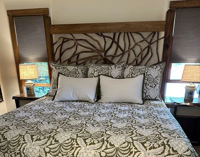 A decorative bed featuring a mountain laurel bed frame in Glenville, NC, showcasing natural beauty and rustic elegance, perfect for enhancing bedroom decor.