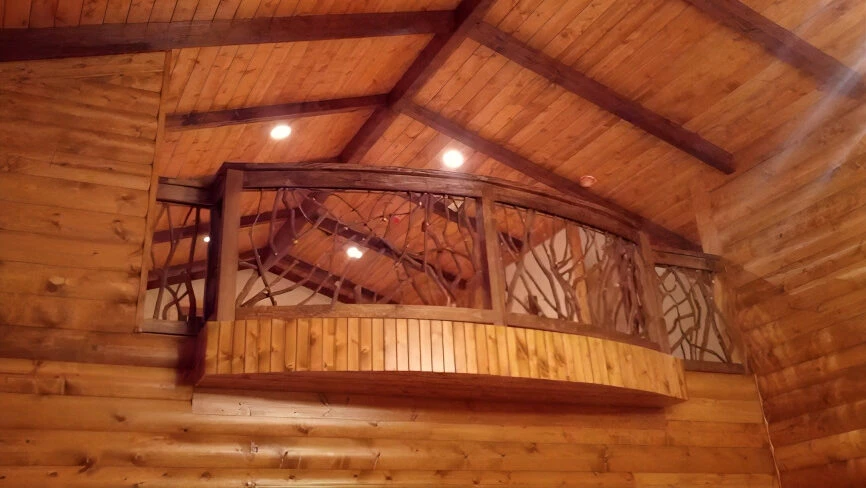 A product photo of a curved Mountain Laurel handrail installed indoors in a fully timber home.