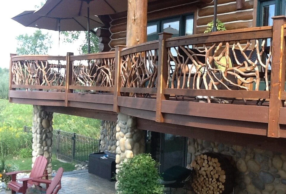 A product photo of curved exterior railings on a large deck, supported by sturdy cobblestone pillars.